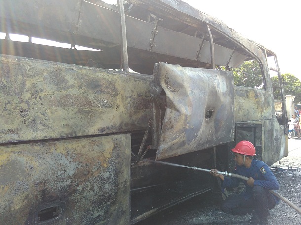 Tim pemadam kebakaran berjuang memadamkan kebakaran bus pariwisata di Jalan Pramuka Langkapura Bandar Lampung, Minggu 6/12/2015. | Andi/Jejamo.com