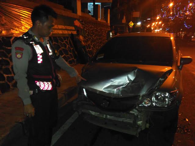 Anggota kepolisian Polresta Bandar Lampung menunjukan mobil rusak usai menabrak pembatas jalan di jalan Teuku Umar Bandar Lampung, Minggu dini hari, 3/4/2016. | Andi/Jejamo.com