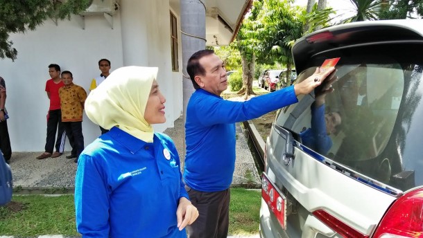 Kepala Dinas Pendapatan Daerah Lampung tengah menempeli mobil dinasnya dengan stiker antikorupsi bersama Kajari Gunungsugih Nina Kartini. | Raeza/Jejamo.com