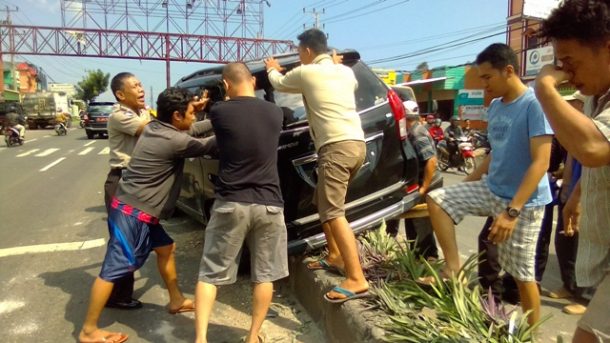 Mobil Tersangkut di Median Jalan Raya Hajimena Natar